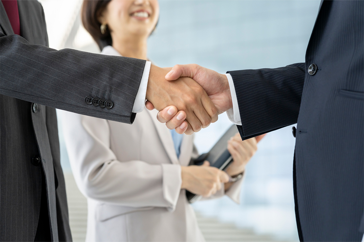 ビジネスマン同士が握手をしている画像